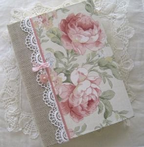 Esse caderno é mais fofo, utilizando tecidos de diferentes texturas, fitas de cetim, renda...